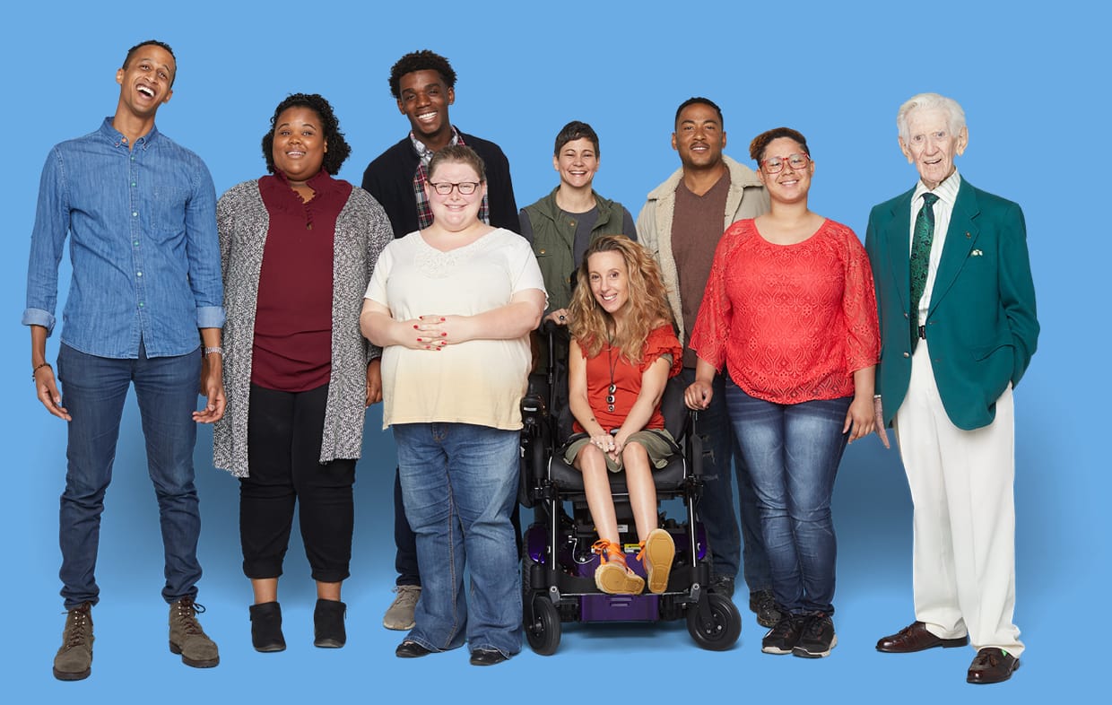 Diverse group of people of various ages, race, and disability smiling to the camera