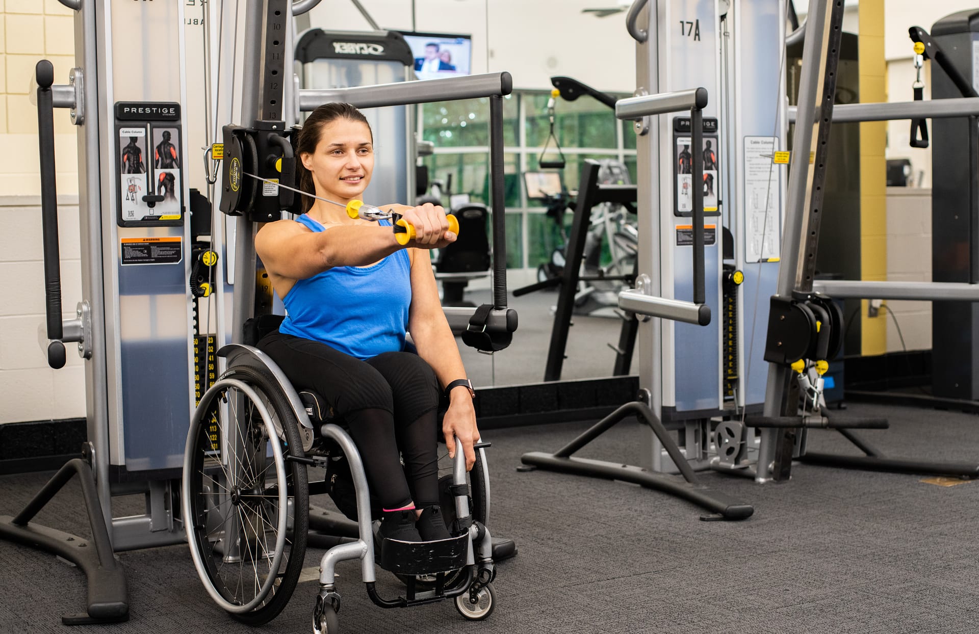 Woman in wheelchair exercising her hand in a gym