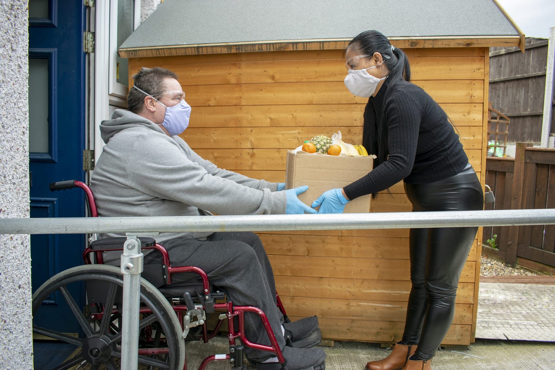 Helper Delivering Food to a Disabled Man in Quarantine During Covid19 Coronavirus Pandemic